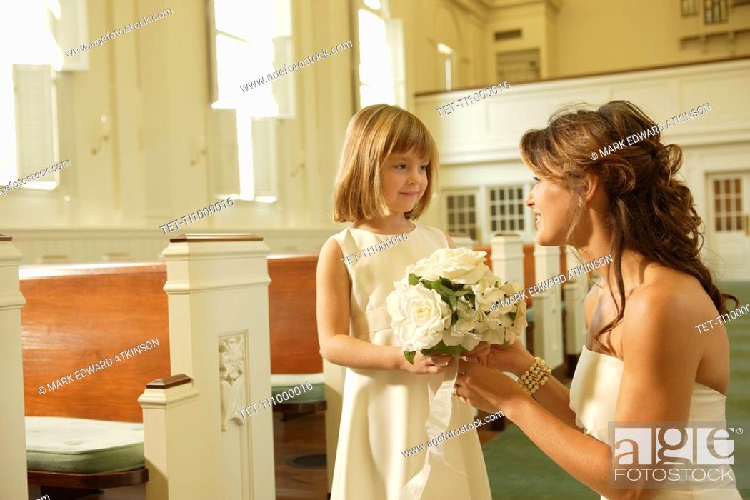 Stock Photo: Bride giving bouquet to flower girl.