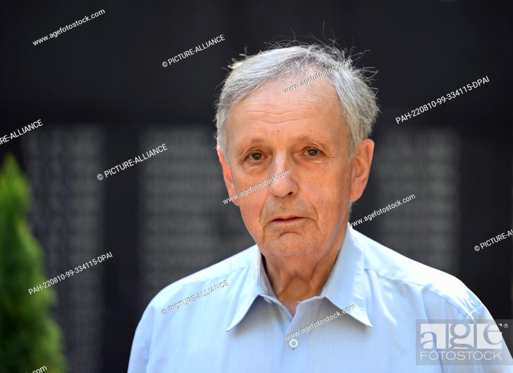 Stock Photo: 02 August 2022, Brandenburg, Wildau: Jörn Lehweß-Litzmann stands in front of the memorial stone for the victims of the 1972 plane crash at the Waldfriedhof.