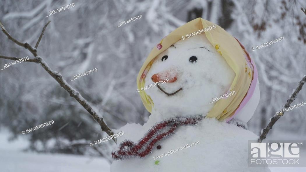 Stock Photo: Happy funny snowman-woman, on background of a strong snowfall. Odessa, Ukraine, Europe.