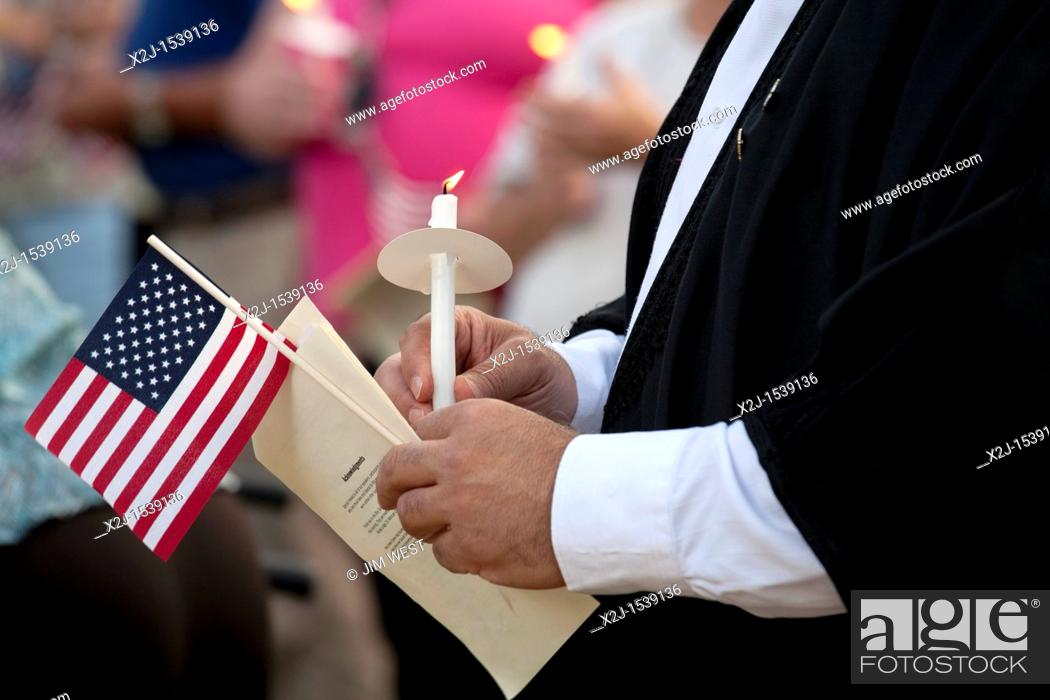 Stock Photo: Dearborn, Michigan - A Muslim imam holds a candle and flag during an interfaith 'Remembrance and Unity Vigil' at The Henry Ford museum commemorating the tenth.