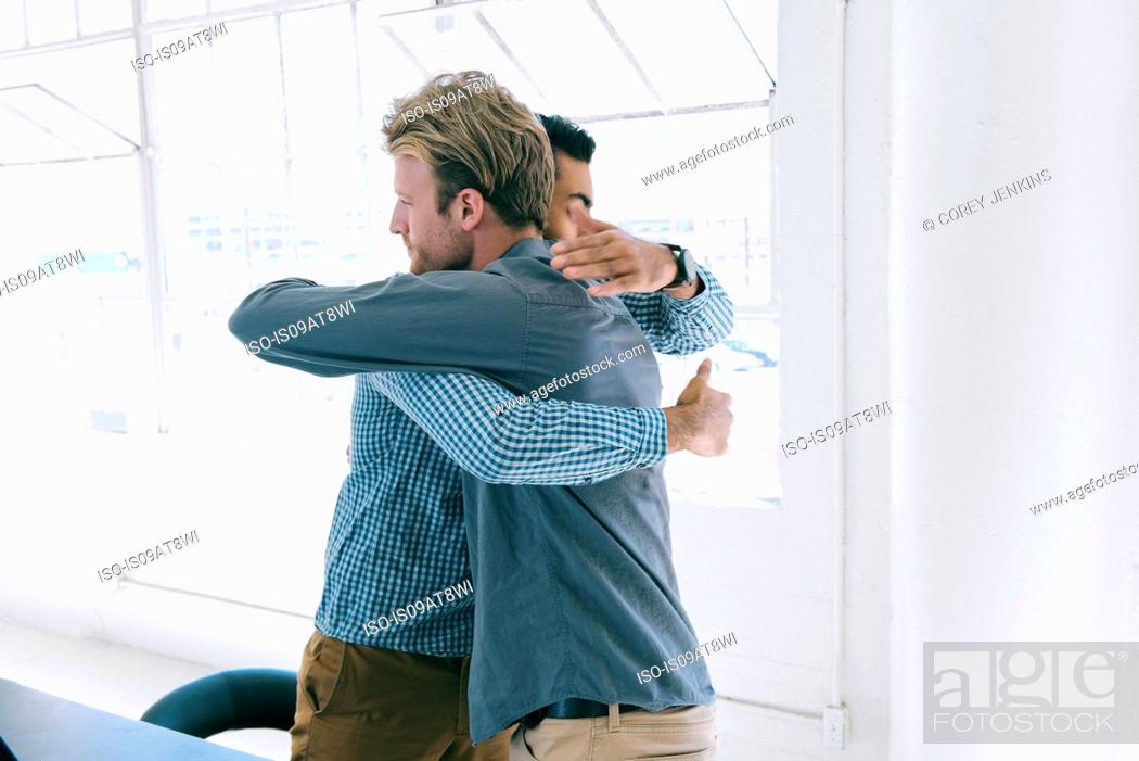 Stock Photo: Business people hugging at meeting.
