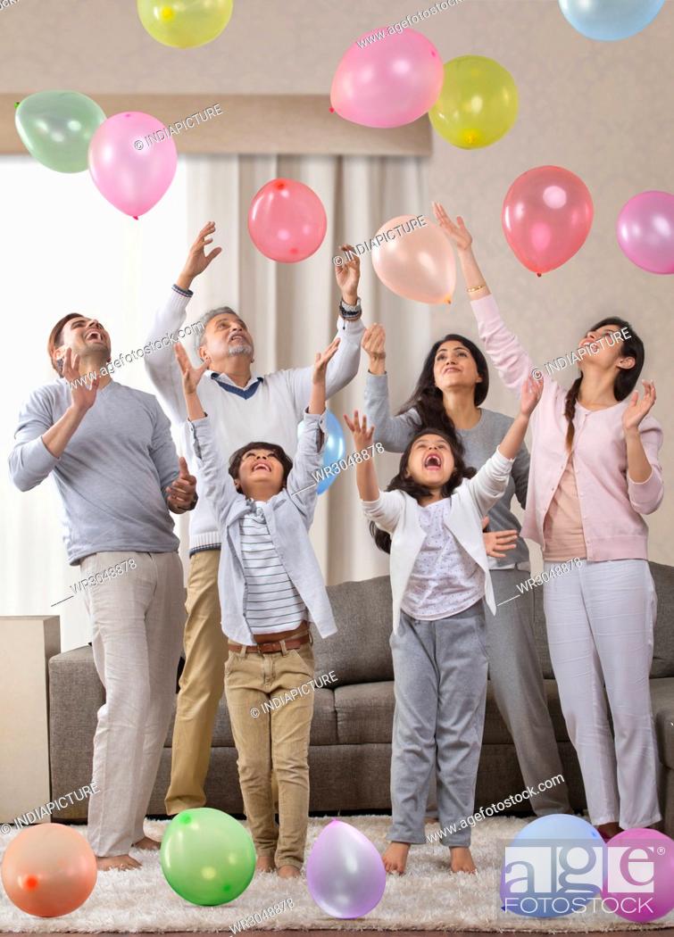 Stock Photo: Multi-generation family playing with balloons.
