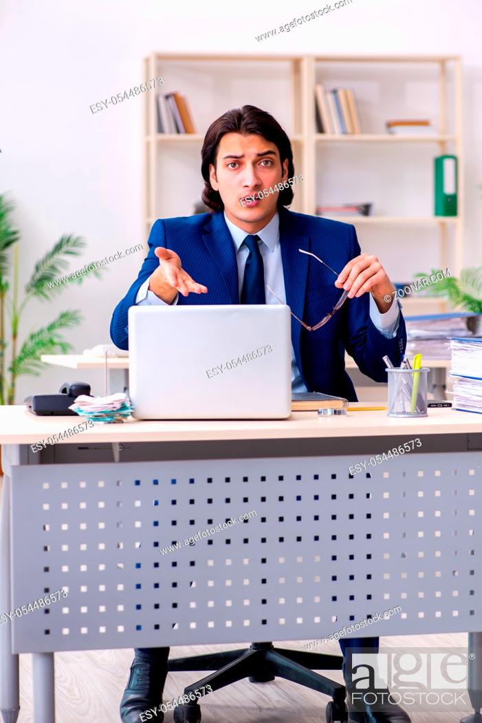 Imagen: The young businessman sitting and working in the office.