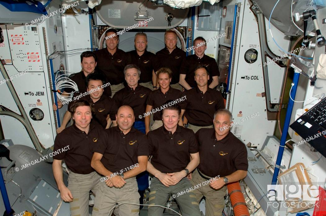 Stock Photo: The STS-127 and Expedition 20 crew members pose for a group portrait in the Harmony node of the International Space Station while the Space Shuttle Endeavour.