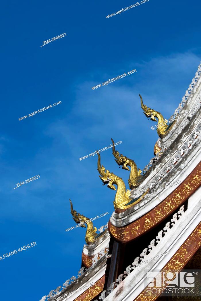 Stock Photo: Detail of the multi-tiered roof which is adorned with stylized Naga finials at the roofÂ’s ends on the Haw Pha Bang (the Royal temple) at the Royal Palace.