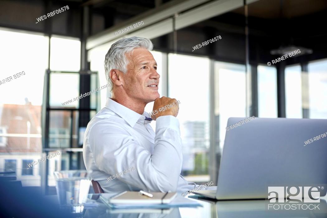 Stock Photo: Businessman sitting in office, thinking.
