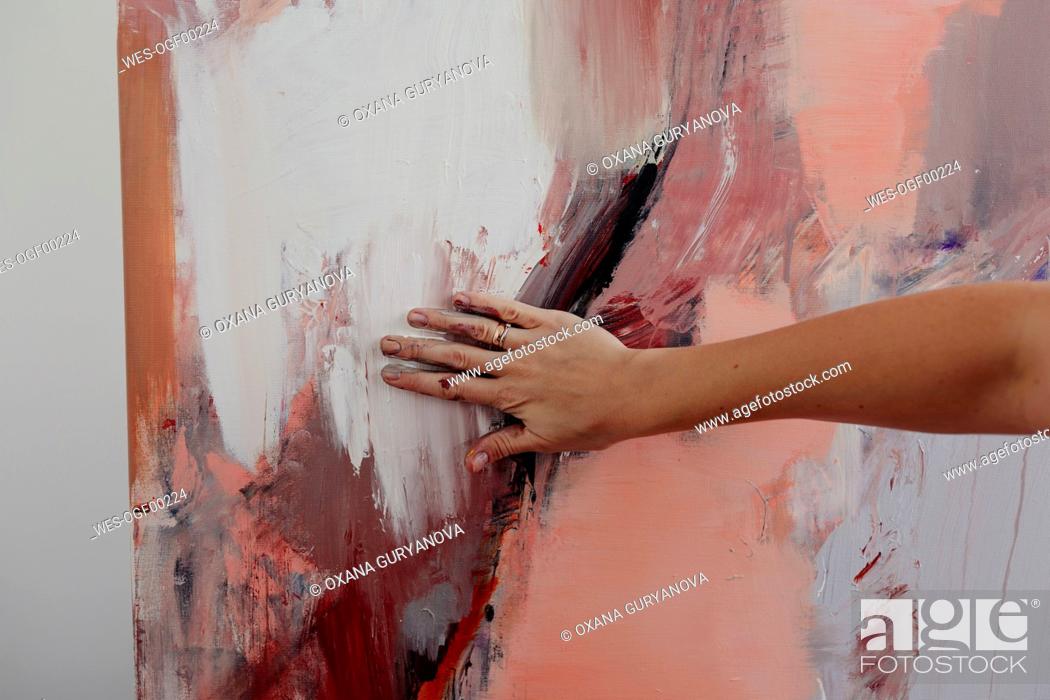 Stock Photo: Hand of a female painter on her painting.