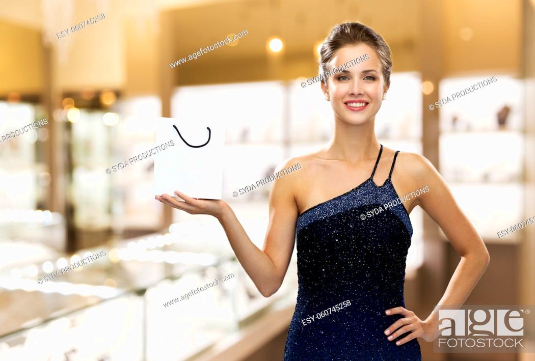 Photo de stock: smiling woman with shopping bag at jewelry store.