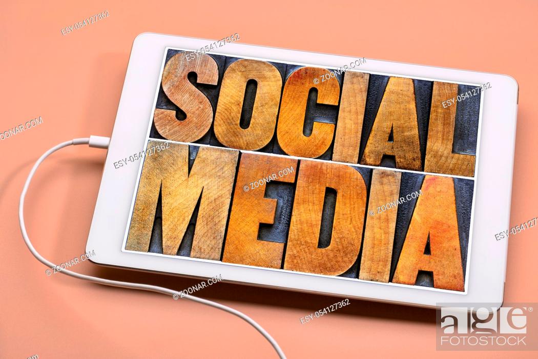 Stock Photo: social media word abstract in antique wood letterpress printing blocks on a screen of a digital tablet.