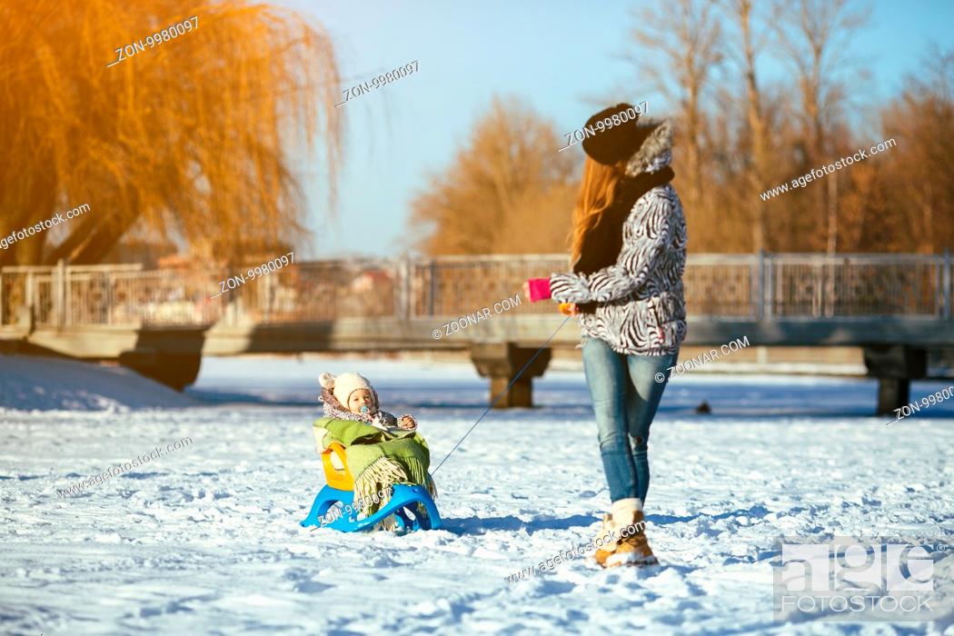 Stock Photo: happy family mother and baby girl daughter playing and laughing in winter outdoors in the snow.