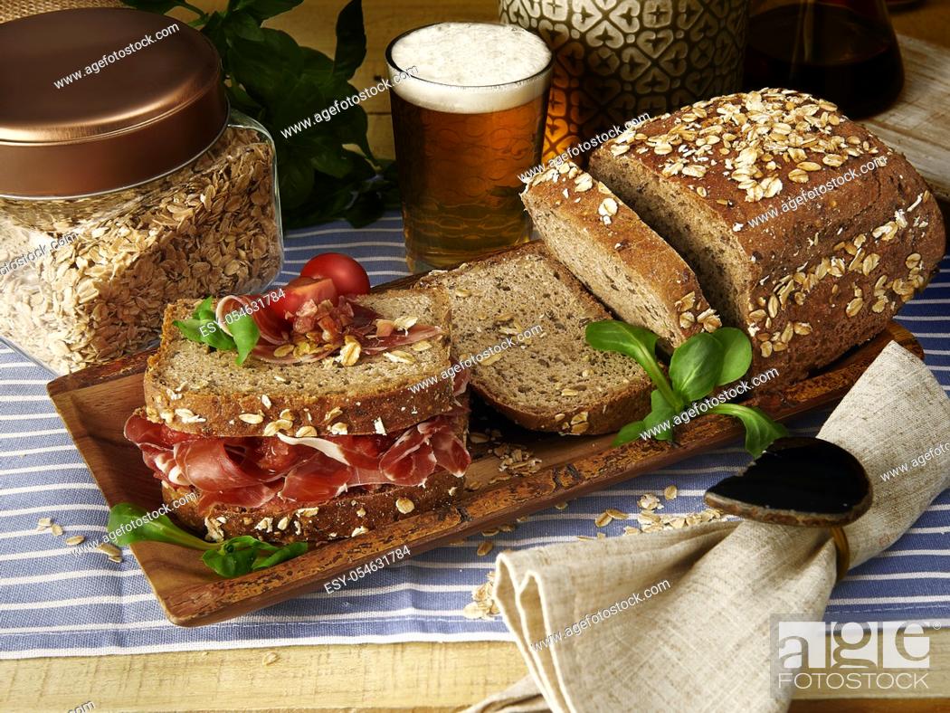 Stock Photo: homemade ham and tomato wholemeal bread sandwich with glass of beer in wood table.