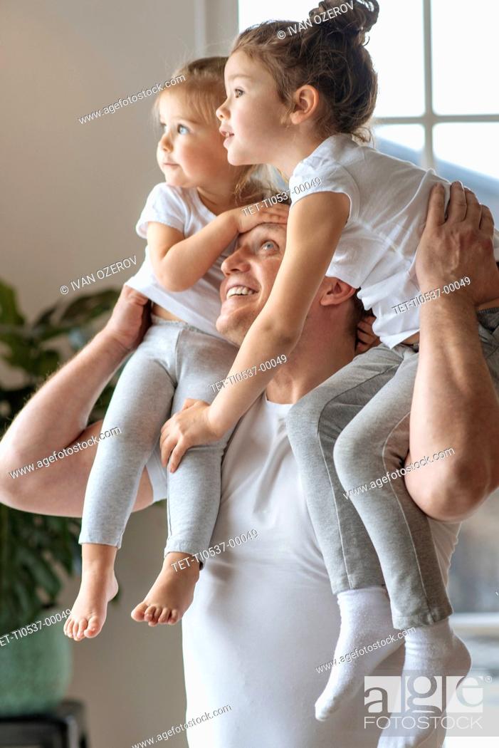 Stock Photo: Father with his daughters on his shoulders.