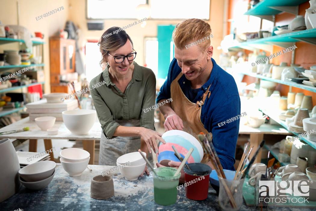 Stock Photo: Male and female potter interacting with each other.
