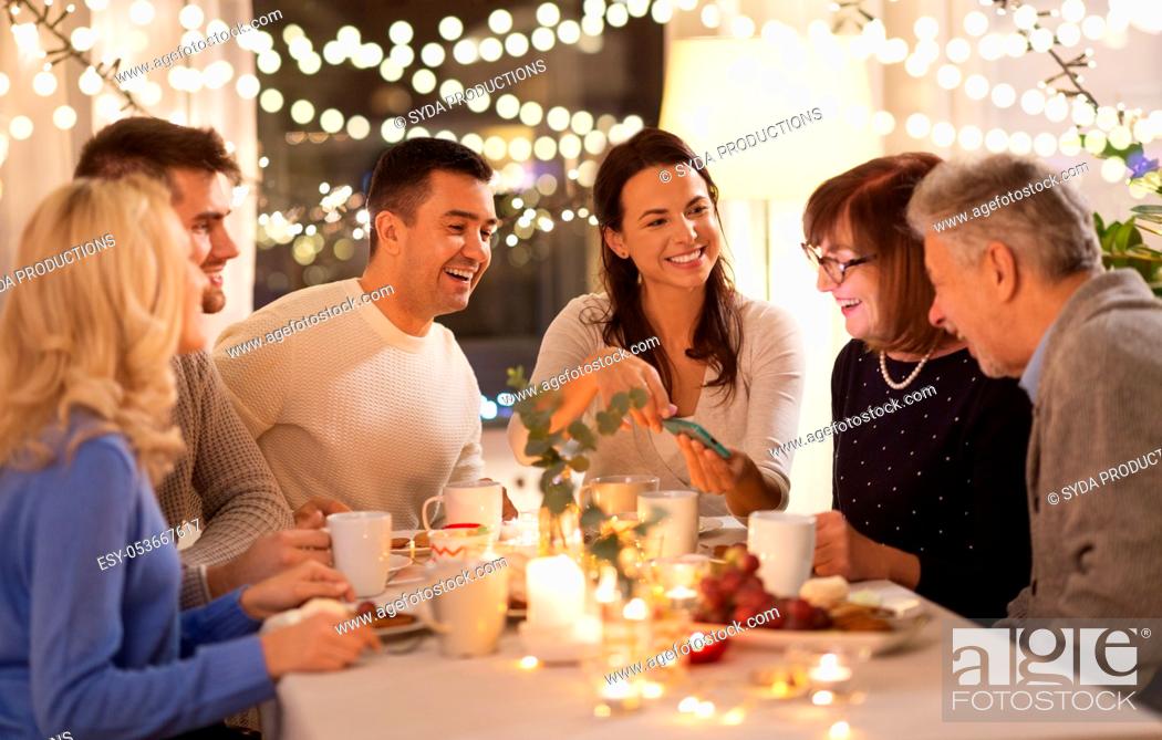 Stock Photo: happy family with smartphone at tea party at home.