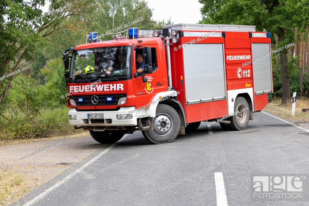 Stock Photo: 25 June 2022, Saxony, Nieska: A fire department drives into the forest to fight the forest fire on the Saxon-Brandenburg border in the Gorischheide nature.