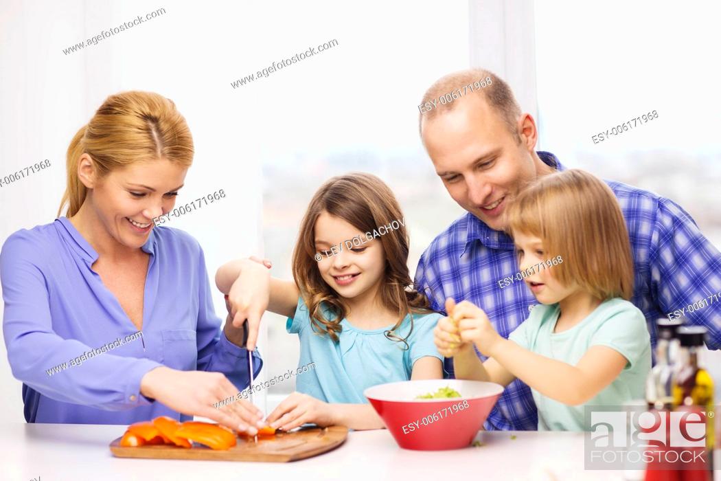 Stock Photo: food, family, children, hapiness and people concept - happy family with two kids making dinner at home.