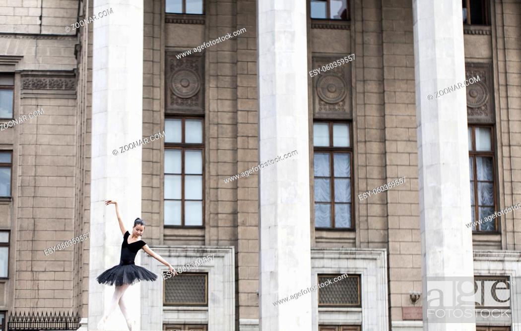 Stock Photo: Girl ballerina flats standing on tiptoes on the street.