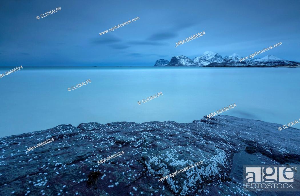 Stock Photo: View of the cold sea and snowy mountains from a rock. Myrland. Lofoten Islands Northern Norway Europe.
