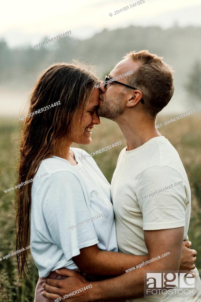Stock Photo: Couple kissing on meadow.