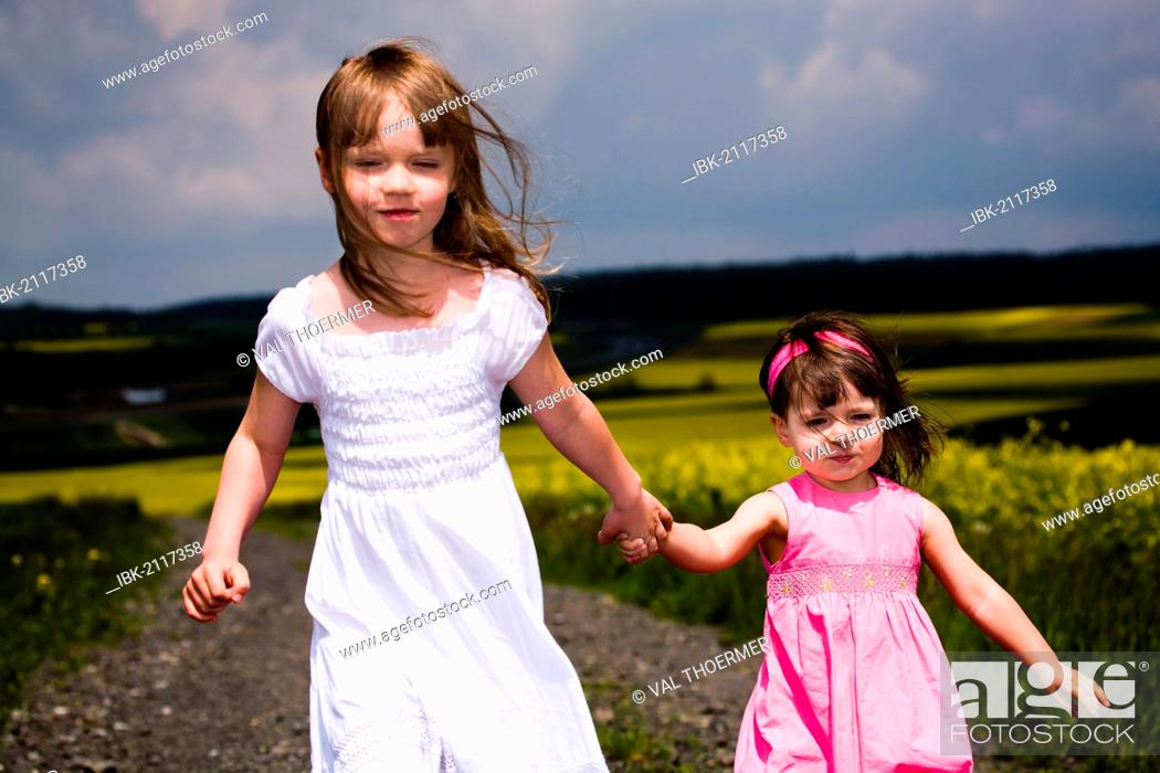 Stock Photo: Two girls walking on field path.