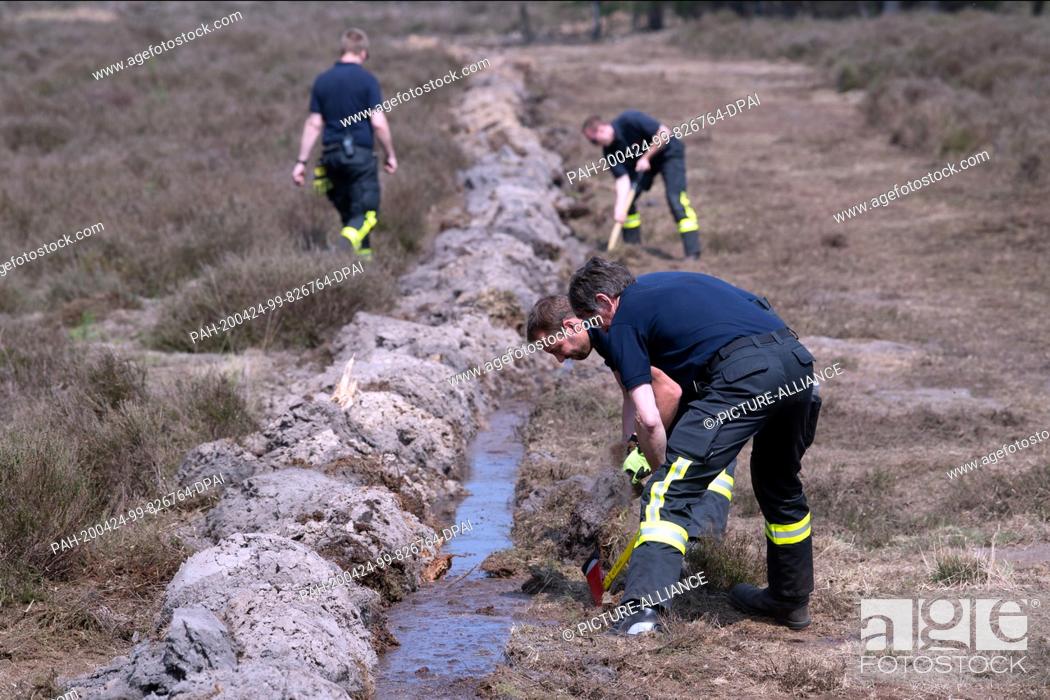 Stock Photo: 24 April 2020, North Rhine-Westphalia, Niederkrüchten: Firemen are working in the forest on a moat. Several days after the outbreak of a large-scale forest fire.