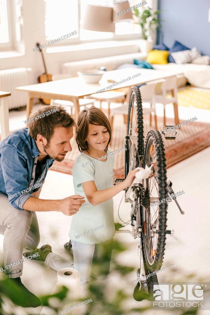 Stock Photo: Father and son repairing bicycle together at home.