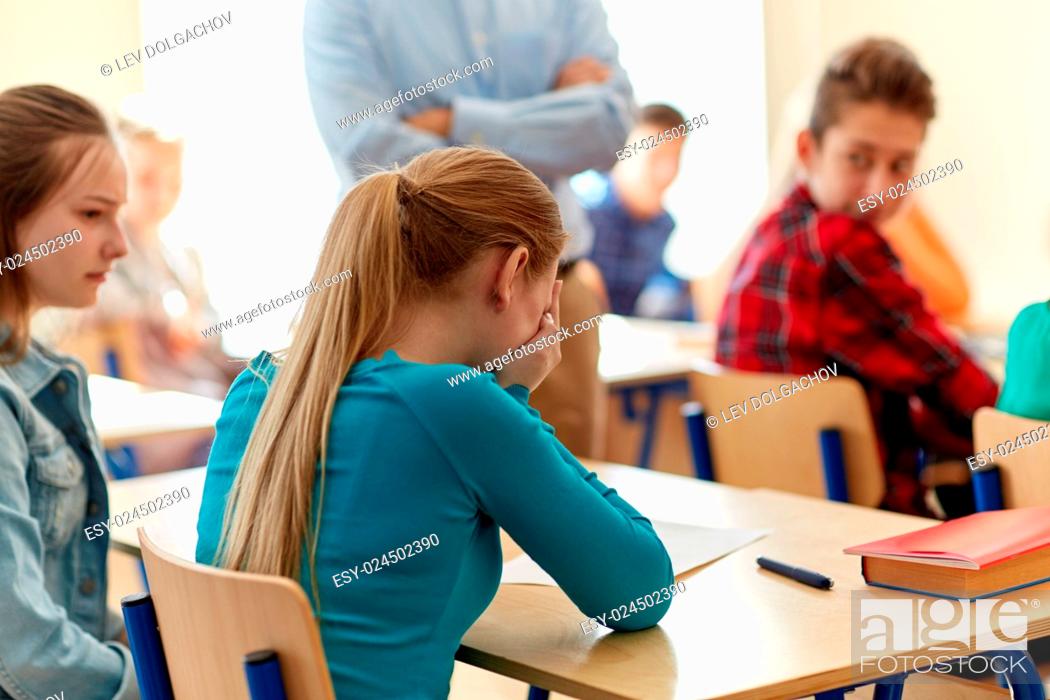 Stock Photo: education, high school, learning and people concept - crying student girl with bad test result and teacher in classroom.