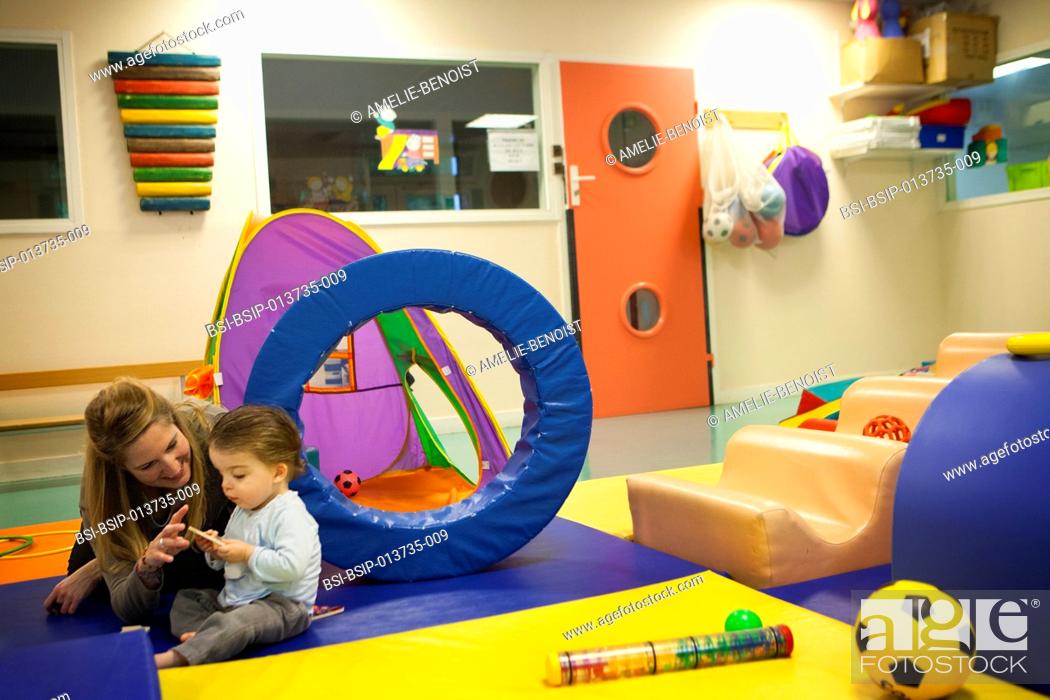 Stock Photo: Reportage on a psychomotor specialist practising in a day nursery in Paris, France. This small 2-year old boy has a delayed growth rate and has psychomotor.