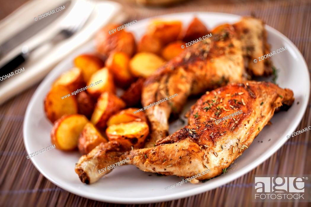 Stock Photo: Roast Chicken Thighs with Potatoes on a Plate.