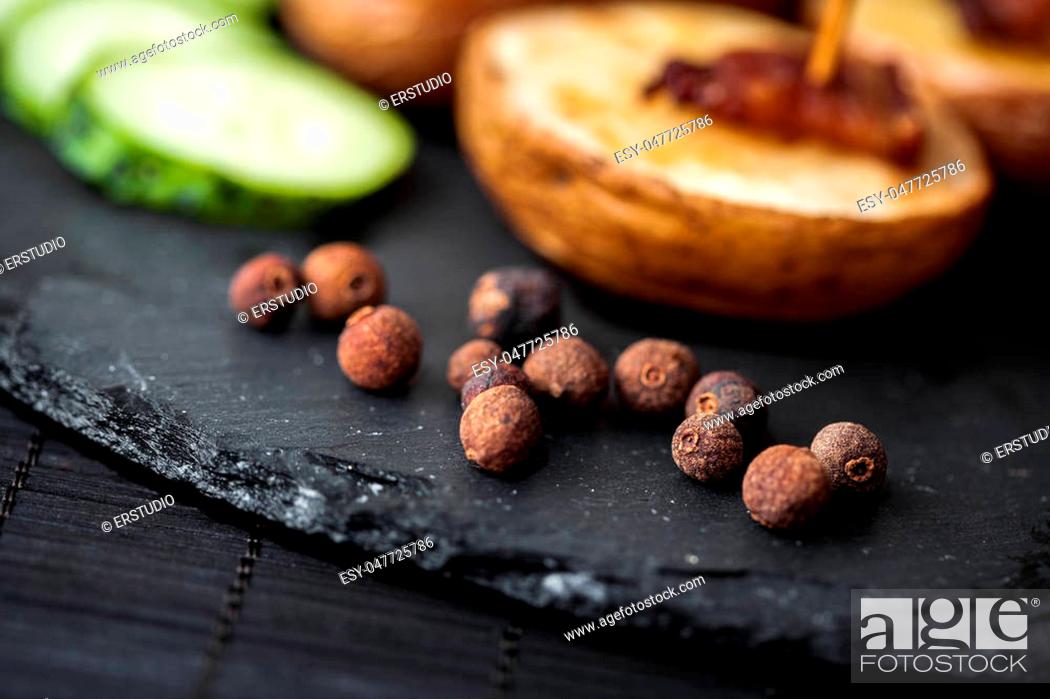 Stock Photo: potato wedges, peas pepper and leg of lamb on black plate closeup.