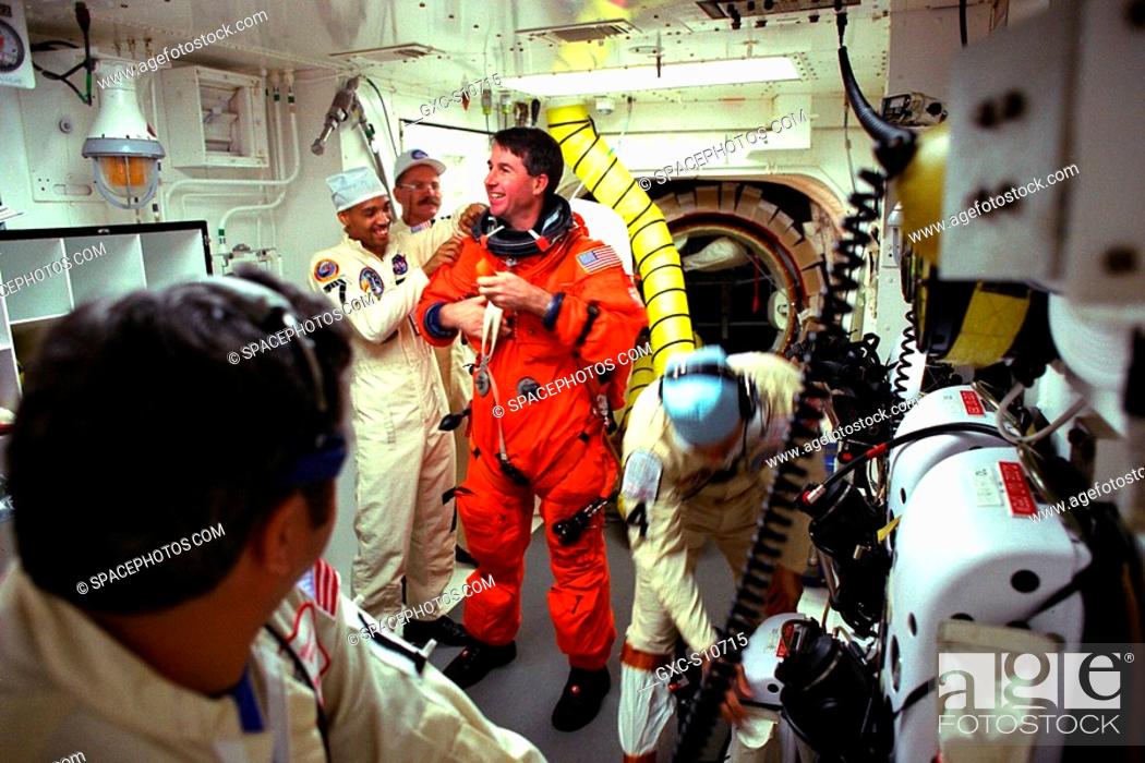 Stock Photo: 08/07/1997 --- STS-85 Mission Specialist Stephen K. Robinson visits with white room closeout crew members Mike Mangione left foreground, Carlos Gillis.