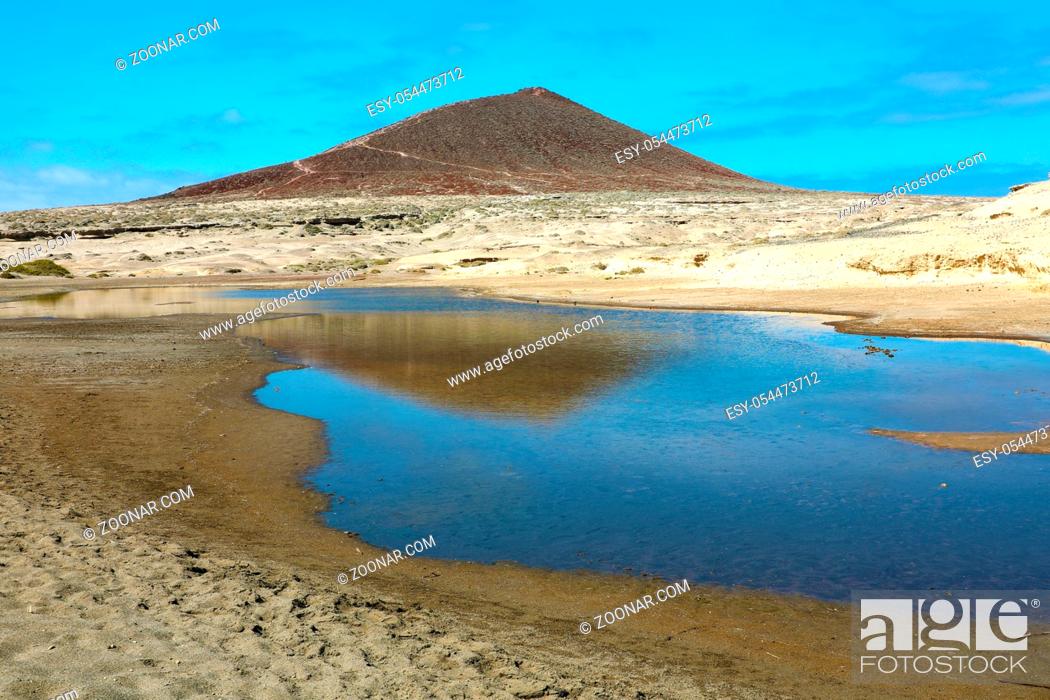 Stock Photo: Amazing view of Montana Roja volcano with pond in natural reserve of sand desert of El Medano, Tenerife, Spain.