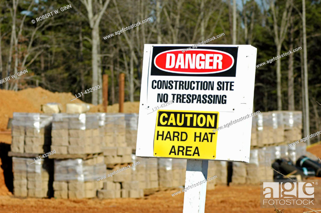 Stock Photo: Warning to use hard hats in construction site due to danger, and no tresspassing.
