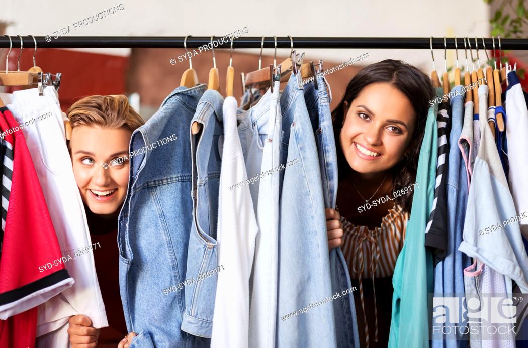 Stock Photo: women having fun at vintage clothing store hanger.