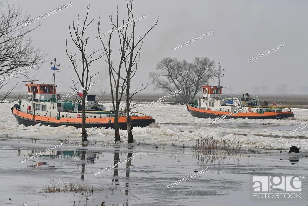 Stock Photo: 18 February 2021, Poland, Zatan Dolna: Two Polish icebreakers are sailing on the German-Polish border river Oder north of Schwedt (Brandenburg).