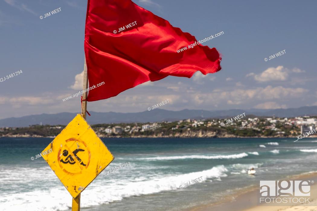 Photo de stock: Brisas de Zicatela, Oaxaca, Mexico - The Pacific Ocean beach, looking towards Puerto Escondido. The red flag warns of dangerous swimming conditions.
