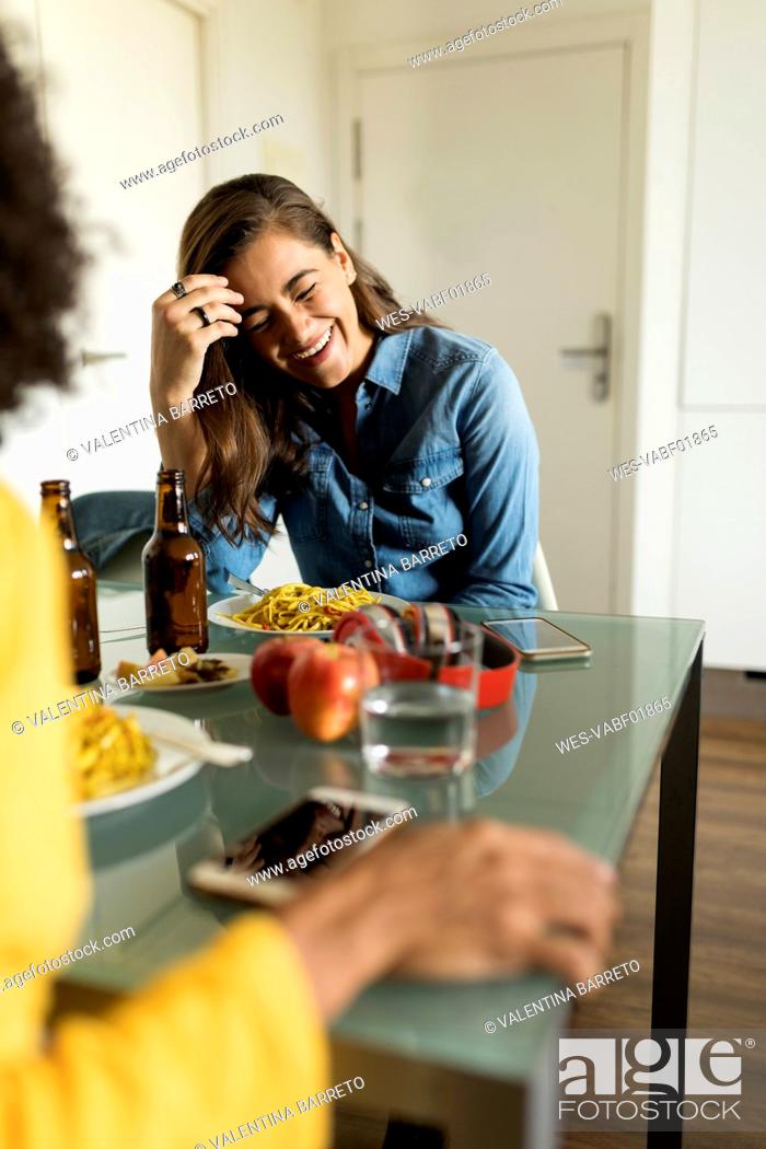 Stock Photo: Girlfriends sitting at table eating and drinking beer.