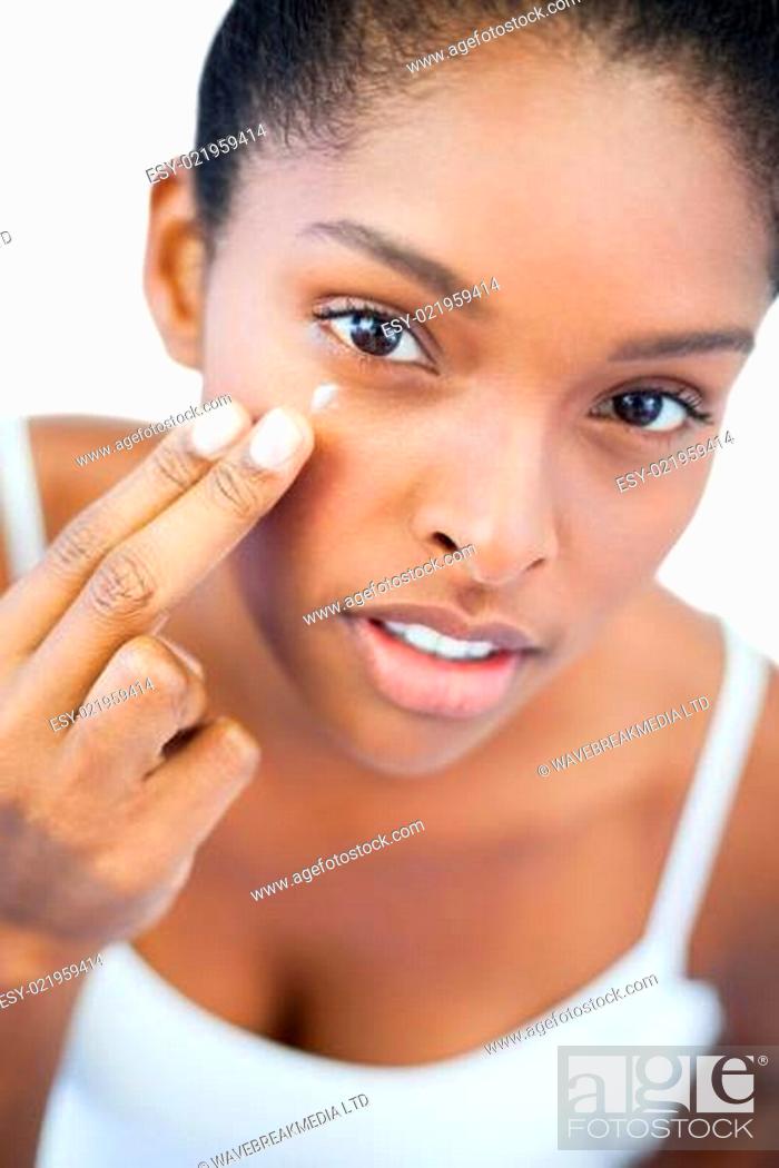 Stock Photo: Pretty woman putting moisturizer on her face.