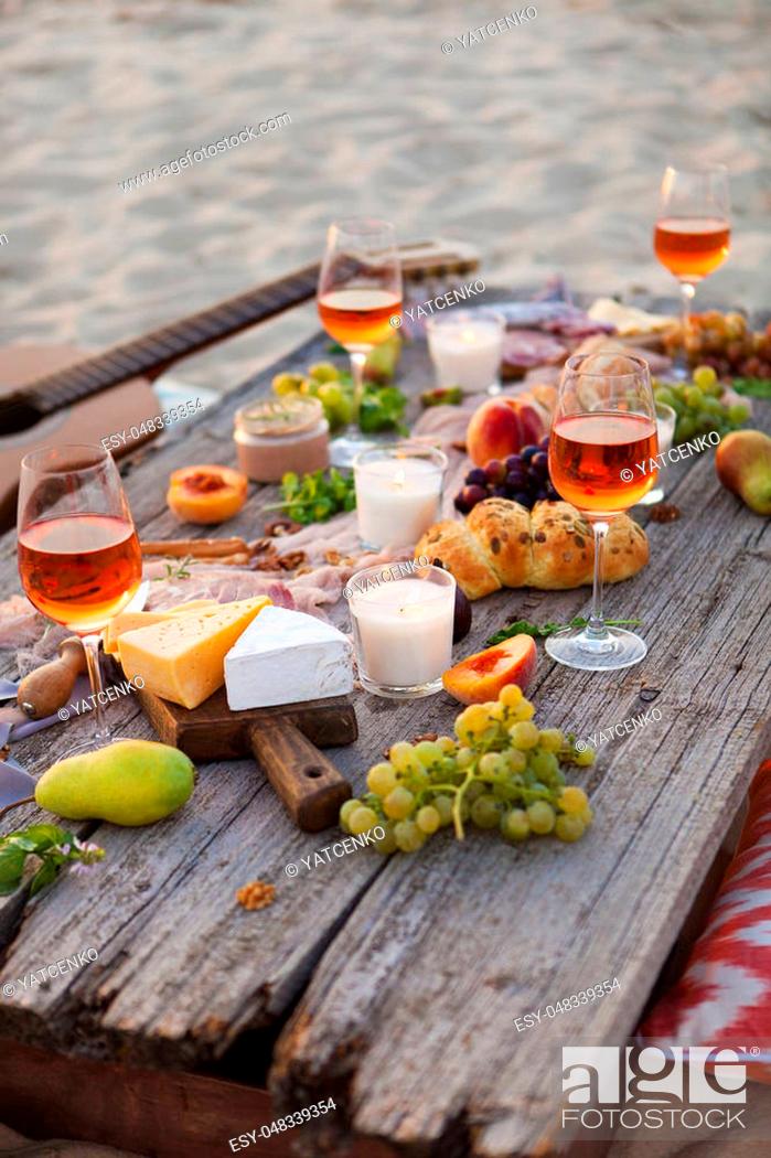 Stock Photo: Picnic on the beach at sunset in the style of boho, food and drink conception.