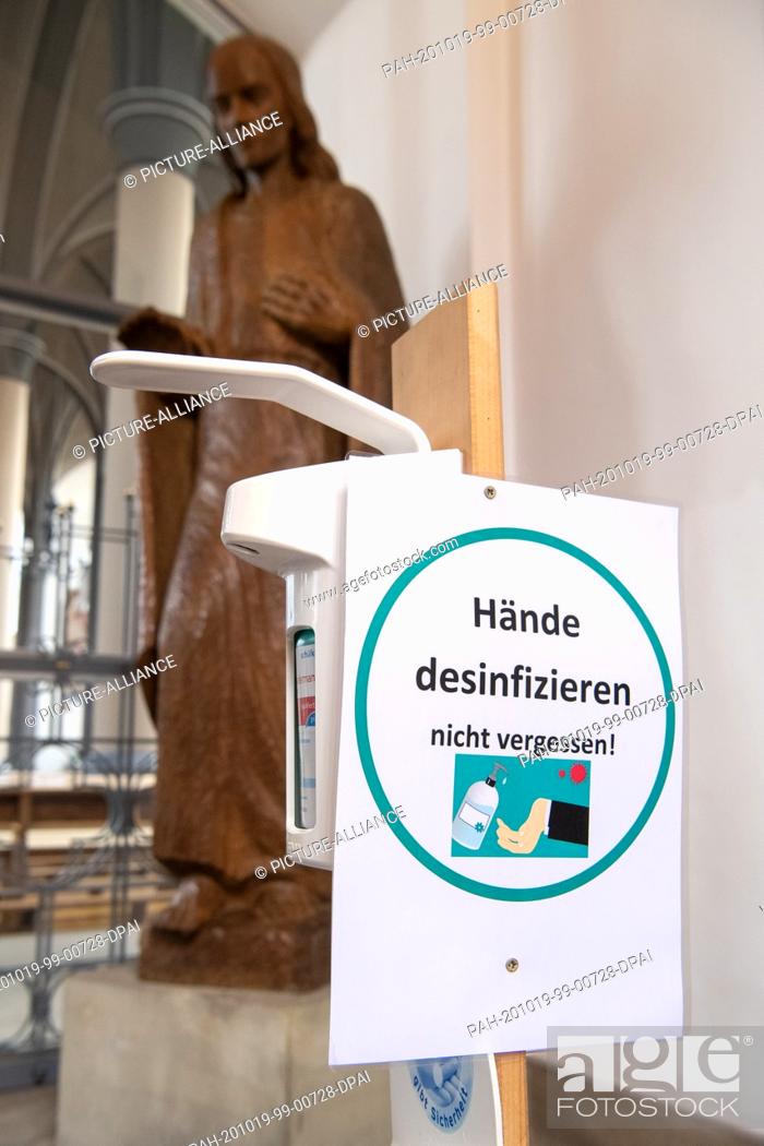 Stock Photo: 19 October 2020, Lower Saxony, Delmenhorst: A sign indicates that hands must be disinfected before entering the church. The city of Delmenhorst near Bremen with.