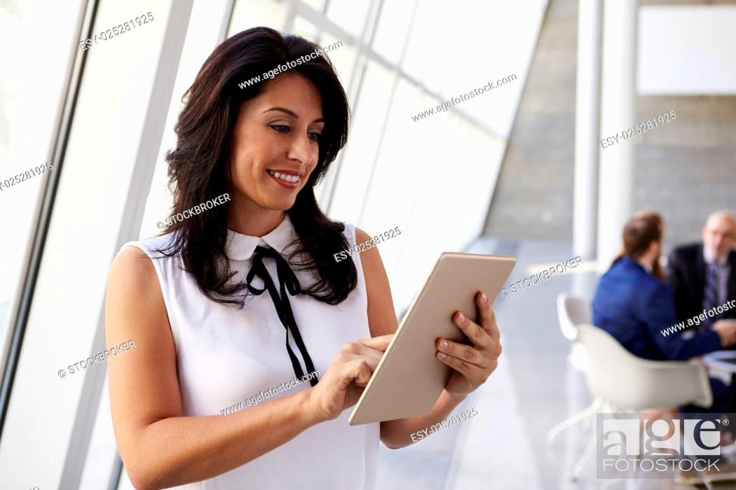Stock Photo: Hispanic Businesswoman Using Digital Tablet In Modern Office.