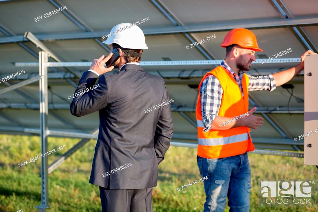 Stock Photo: Director and engineer, solar panels construction. Head of solar station talking on phone.