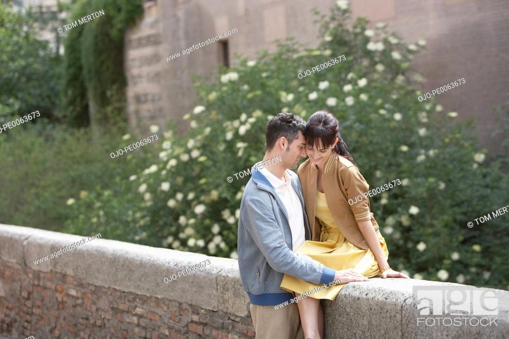 Stock Photo: Couple hugging on stone wall.