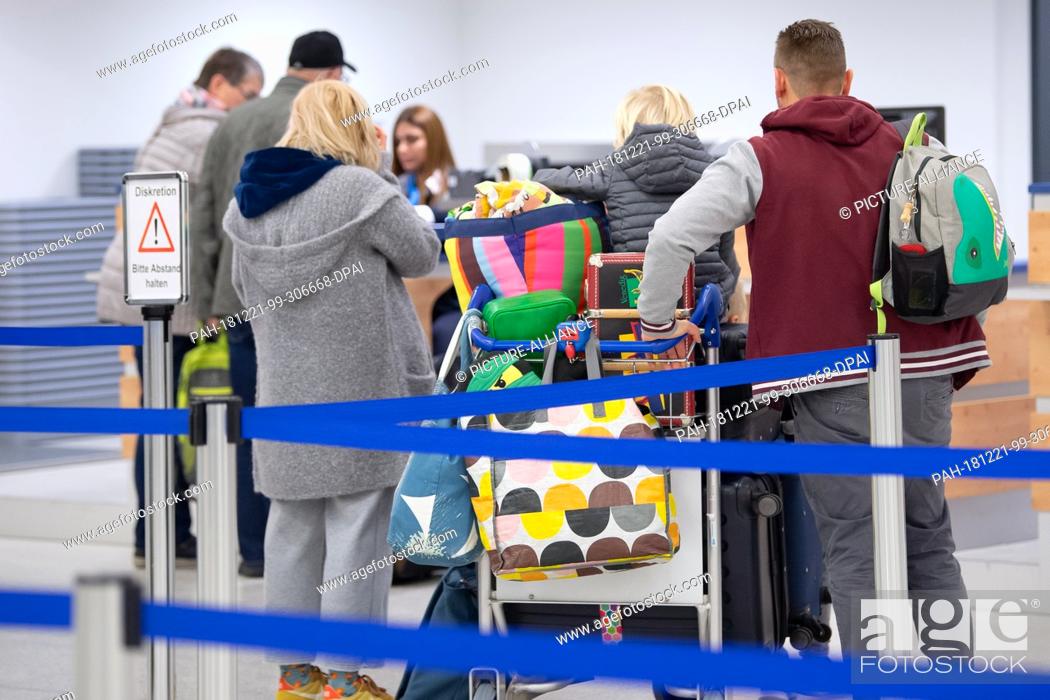 Stock Photo: 14 December 2018, Hessen, Calden: Passengers with baggage are checked in at the airport terminal at Kassel Airport. The airport in northern Hesse is the second.