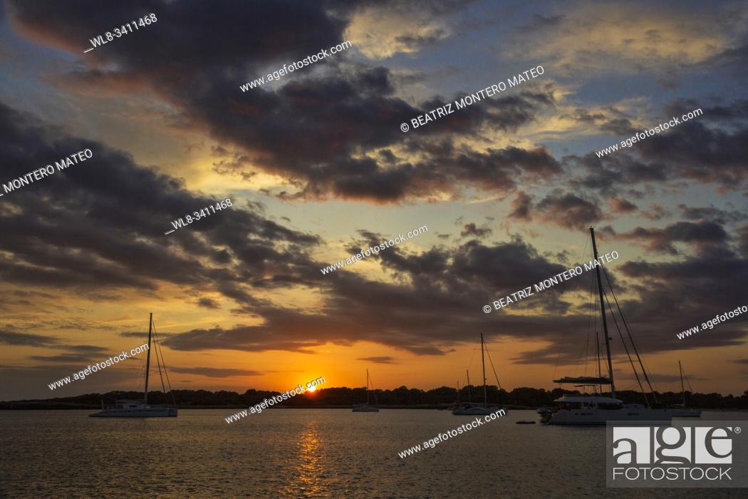 Imagen: Sunset on San Saura's beach in Menorca (Baleares, Spain) with a boats in the sea. Awesome sky.