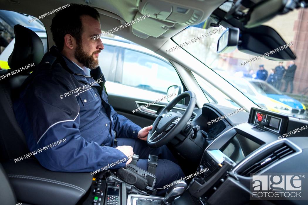 Stock Photo: A police officer sitting inside a patrol car of the Ford S-Max type during a press conference by the North Rhine-Westphalia police in Duesseldorf, Germany.