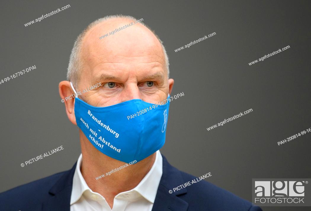 Stock Photo: 14 August 2020, Brandenburg, Potsdam: Dietmar Woidke (SPD), Minister President of Brandenburg, wears a blue mouth-nose guard with the inscription ""Brandenburg.
