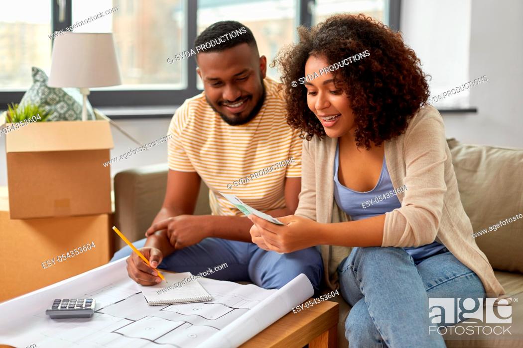 Stock Photo: couple with blueprint counting money at home.