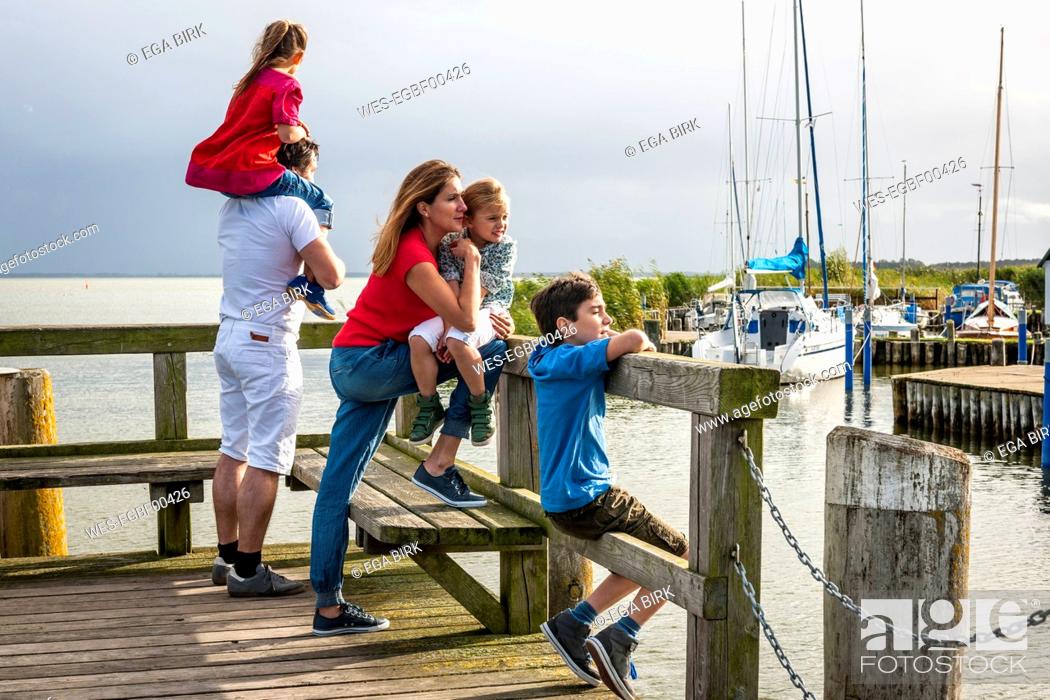 Stock Photo: Family standing on a pier looking at view, Ahrenshoop, Mecklenburg-Western Pomerania, Germany.