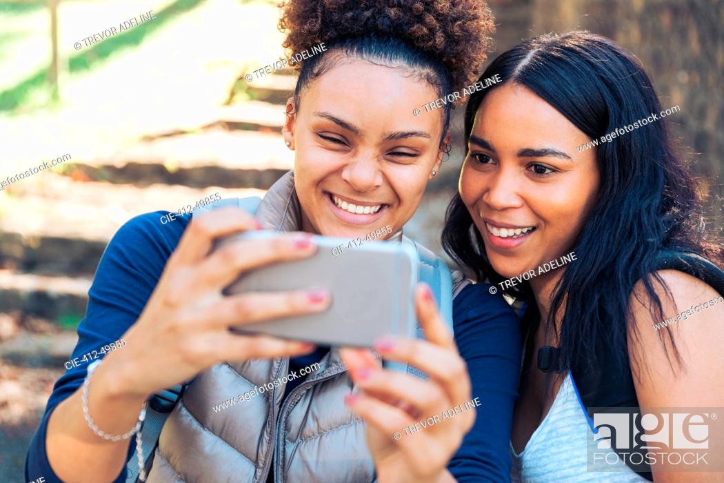 Stock Photo: Happy young women friends taking selfie with smart phone.